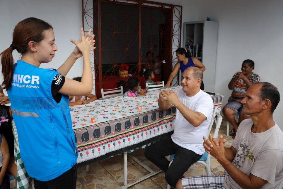 Woman teaching group of people how to wash hands to prevent the spread of COVID-19