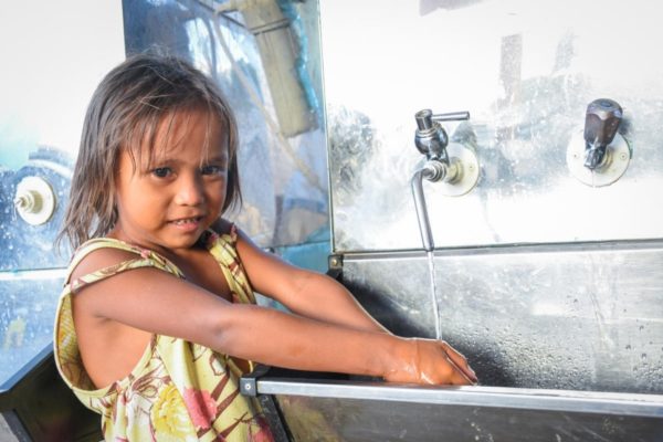 A young girl is seen washing her hair