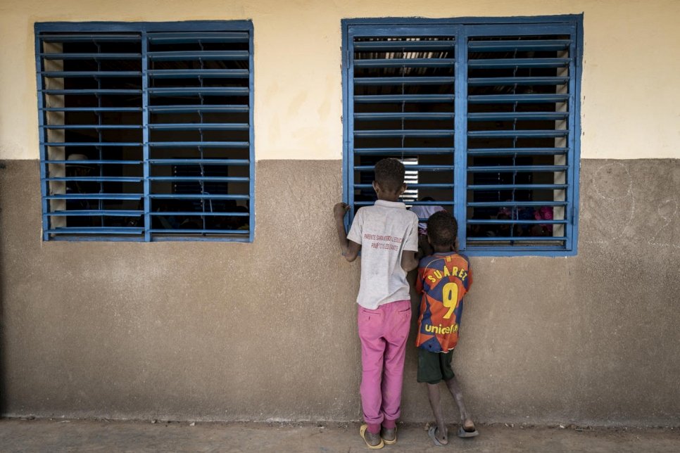 Two cildren look into a window in Burkina Faso