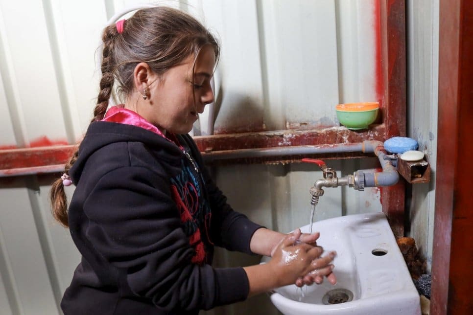 A girl washes her hands