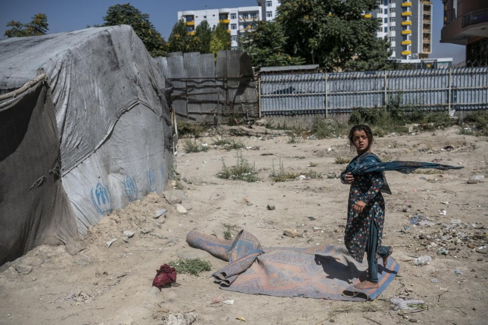 A child walks through a camp for internally displaced people in the Afghan capital, Kabul, July 2019