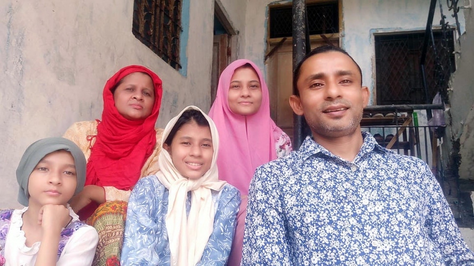 Nezamudden Linn, a 44-year-old Rohingya refugee, sits with his family in New Delhi, India