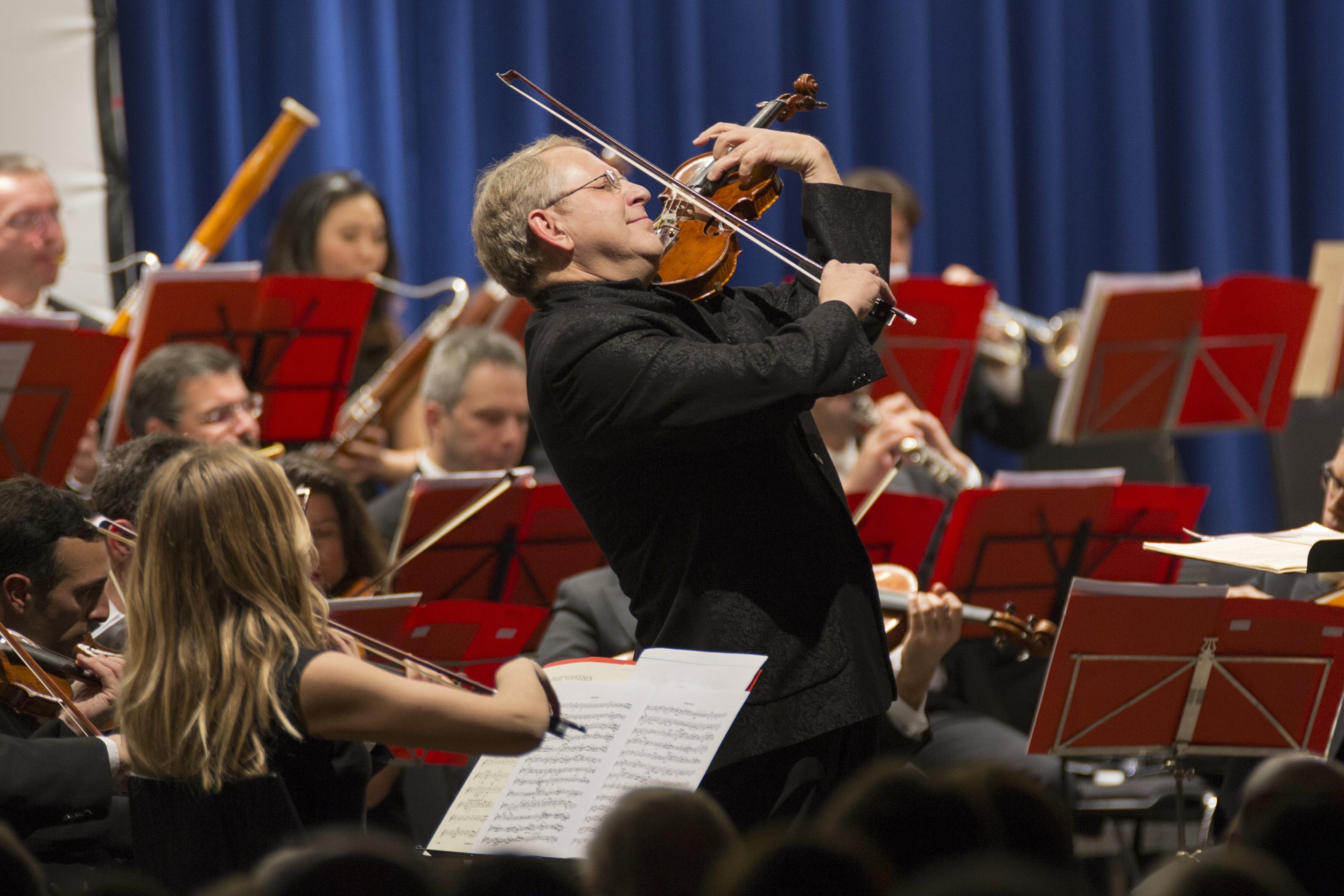 a man playing violin in an orchestra