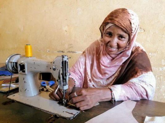 Fatima, a refugee from Mali, uses a sewing machine to make face masks at a workshop in Niamey
