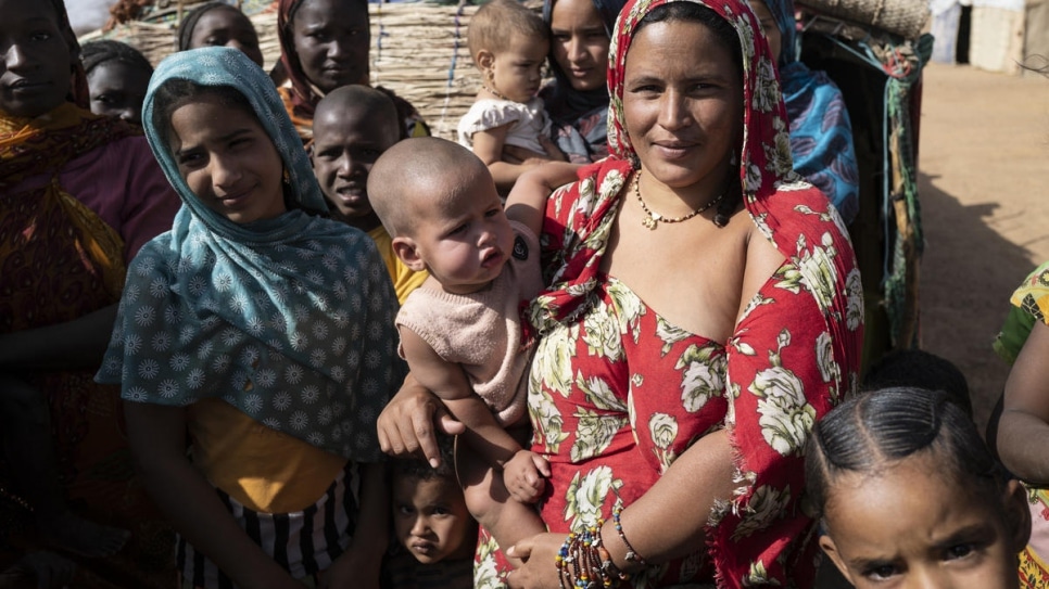 Fatima et son bébé, parmi des refugies maliens attendant une distribution de kits d'hygiène, au camps de Goudoubo, au Burkina Faso