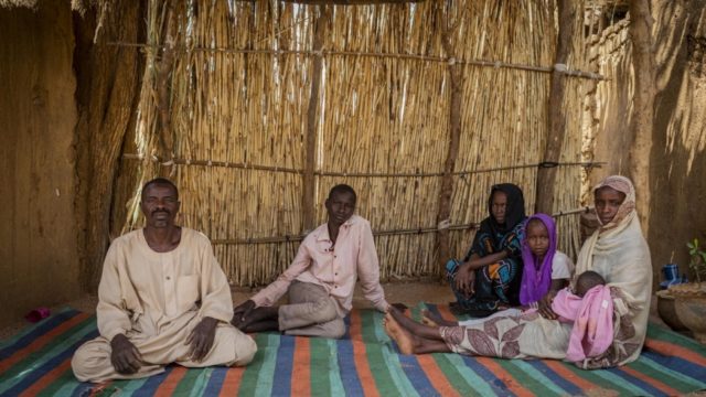 Ahmed Ishag Babiker, 54, sits with his children at their house in Kabkabiya, North Darfur, Sudan. He and his family were internally displaced in 2004 by conflict in Sudan's Darfur region