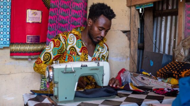 A refugee tailor makes facemasks at Samir's Design Shop_One in Kenya's Kakuma camp – one of the many refugee-run businesses helping fight COVID-19