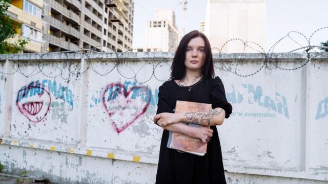 Anna Miryasheva, a 22-year-old stateless woman from Kyiv in Ukraine, holds a photo album containing pictures of her late mother, Olena