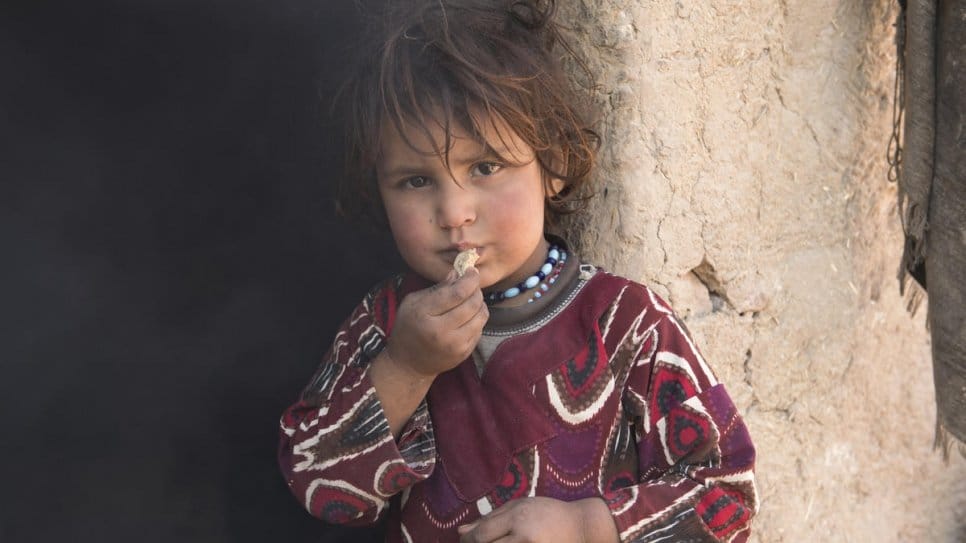 Four-year-old Malali eats bread made by her grandmother, Sadar Bibi. The family returned to Afghanistan after 30 years living as refugees in Pakistan