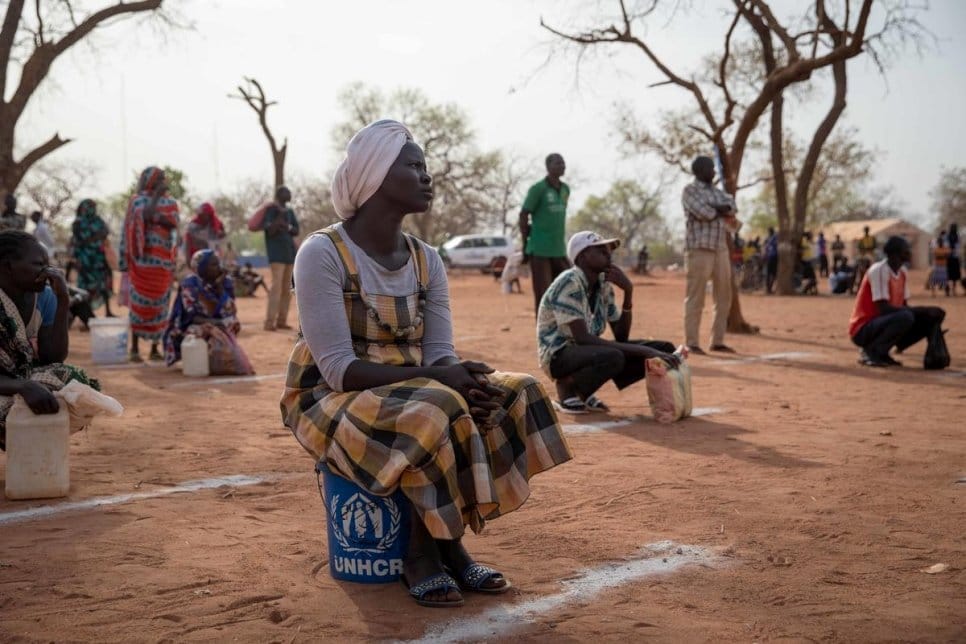 Des réfugiés soudanais se tiennent à distance les uns des autres lors d’une distribution de nourriture et de savon au camp d’Ajuong Thok au Soudan du Sud, en avril 2020