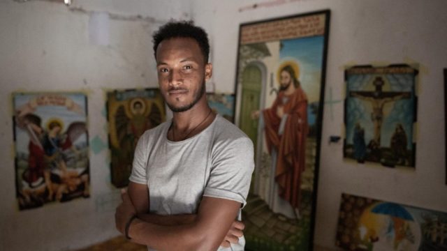 Le réfugié érythréen Solomon Gebreyonas Alema, 29 ans, devant son oeuvre à son domicile à Tripoli, en Libye