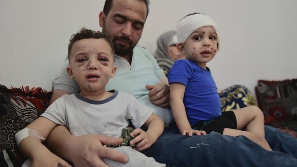 Syrian refugees Ahmed and Aisha Kallout sit on the sofa at a relative's house in the suburb of Dekwaneh with their sons, Zakariya (in blue) and Yahya. All except Ahmed were injured in the Beirut blast