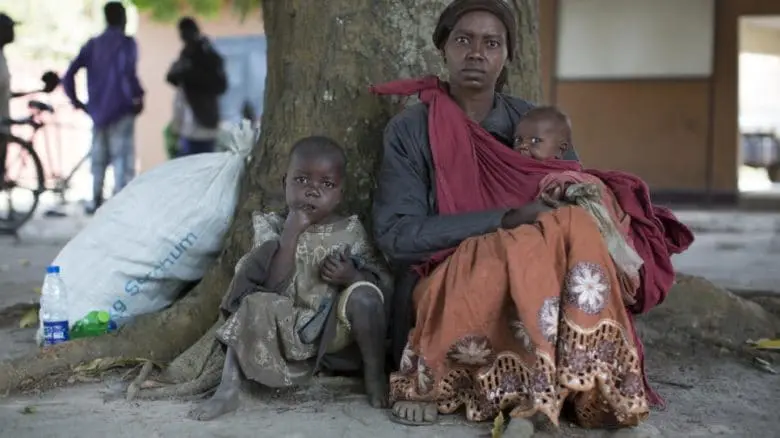 Joyce, une réfugiée congolaise, et ses enfants attendent de monter à bord d'un camion du HCR pour se rendre au camp de Makpandu, au Soudan du Sud