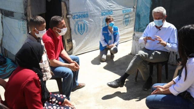 Filippo Grandi s’entretient avec Khalil et sa famille devant leur abri dans un campement informel de la plaine de la Bekaa, au Liban