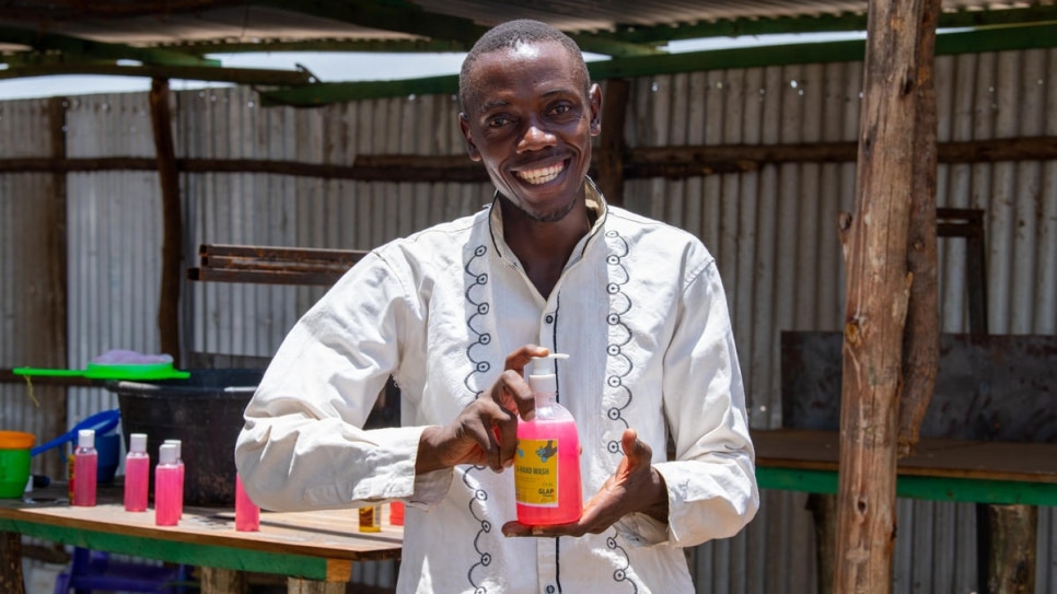 Innocent Havyarimana, un producteur de savon burundais, tient un récipient de désinfectant pour les mains fraîchement fabriqué, qu'il vend à prix réduit à ses pairs réfugiés à Kakuma, aux travailleurs humanitaires et aux Kényans de la communauté locale, pour aider à la lutte contre la crise de Covid-19
