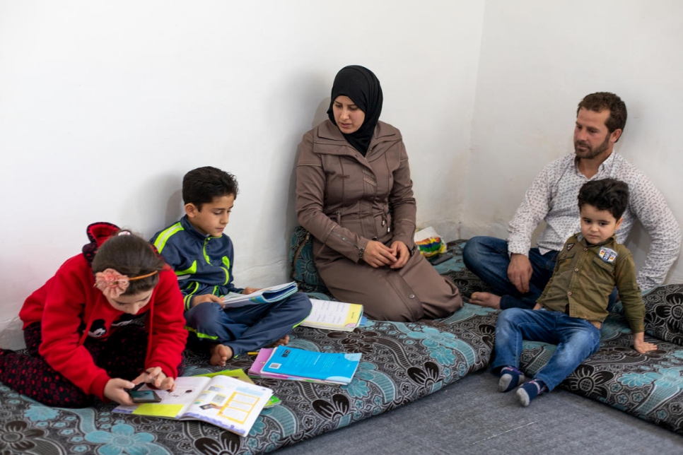 Le réfugié syrien Naeem (à droite) et sa femme Salwa (au centre) sont assis chez eux avec leurs enfants à Amman en Jordanie, pendant le confinement pour endiguer la pandémie de Covid-19