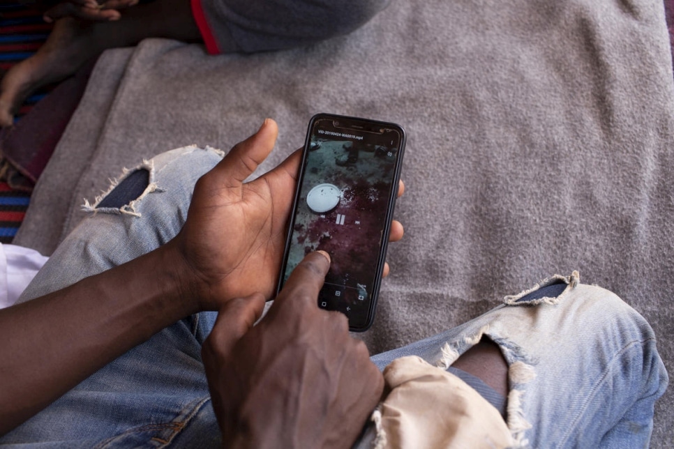 Le demandeur d’asile soudanais Yasir a été détenu illégalement par une milice en Libye. Evacué au Niger, il consulte son téléphone dans le camp du mécanisme de transit d’urgence du HCR dans la banlieue de Niamey. Photo d’archives, mai 2019