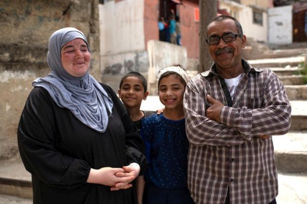 Syrian refugees Mustafa and Sherin stand with two of their children, Nadia, 12, and Muhammad, 10, outside their home in Amman during the COVID-19 lockdown. They fled Damascus in 2013