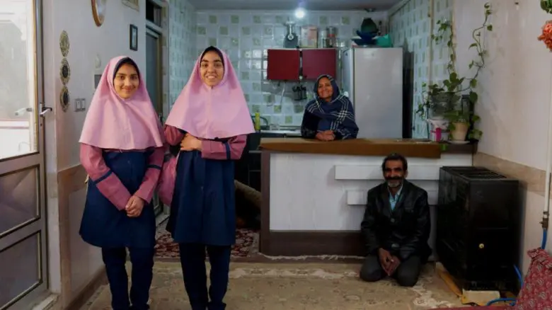Afghan refugee Besmellah (right) and his wife Halime pose for a photograph with their daughters Parimah (far left), 14, and Parisa, 16, at home in Isfahan, central Iran