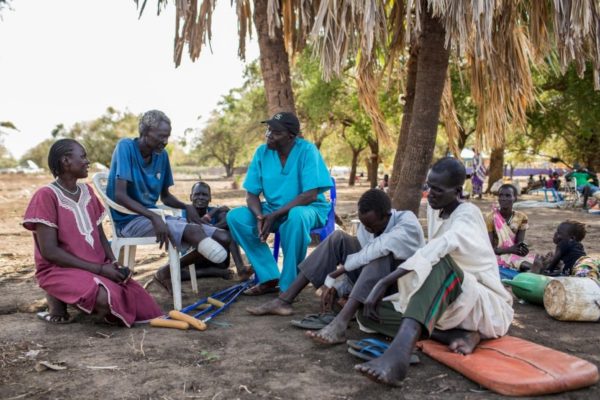 Dr. Evan Atar chats with patients outside Bunj hospital in Maban county, South Sudan.