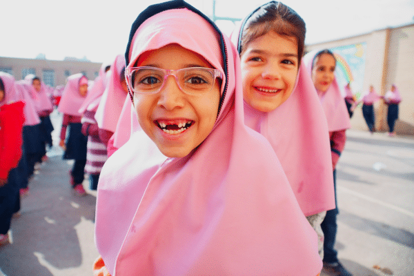 Schoolgirls smile at the camera at Vahdat school in Isfahan, Iran.