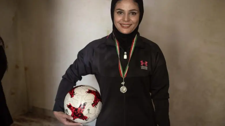 Afghan woman holding soccer ball
