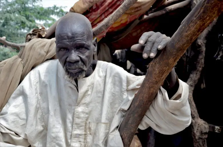 South Sudanese refugee, Bak, 80, sits in his shelter that was damaged by massive flooding in Sharq Al-Nile, Sudan. 