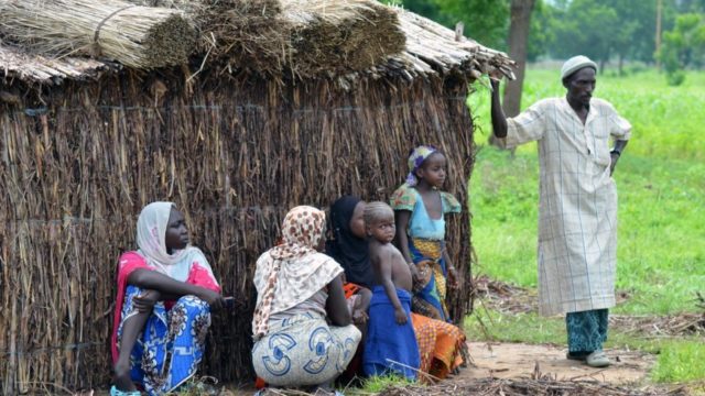 Des personnes attendent après l'attaque d'un site de déplacés internes à Nguétchéwé, dans le nord du Cameroun