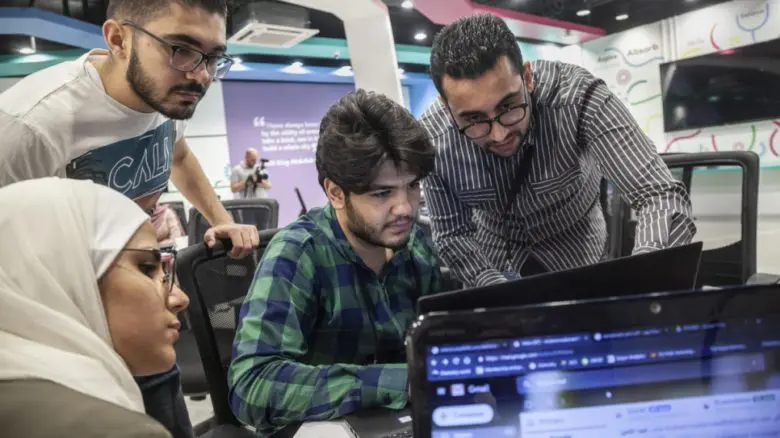 Syrian refugee Ehab Kahwati (right) teaches a digital workshop to students at Yarmouk University, Jordan. 