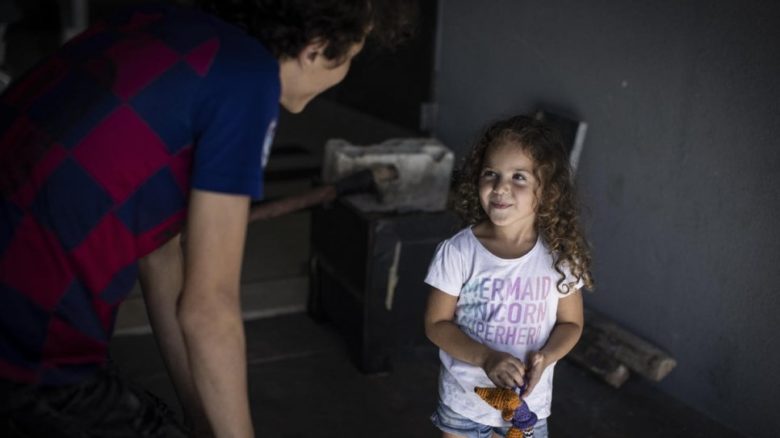 Manar, une réfugiée syrienne de quatre ans, en train de jouer avec son frère Jamal dans leur logement de Beyrouth.