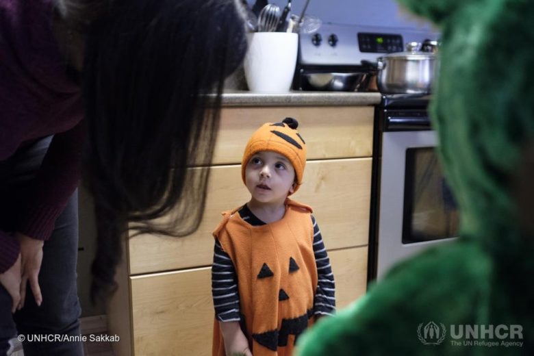 A young Syrian refugee dressed as a pumpkin for Halloween