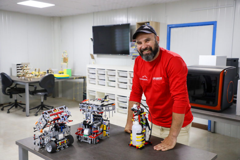Syrian refugee Marwan al-Zoubi poses with the LEGO robot he helped design at the Innovation Lab in Za'atari camp, Jordan