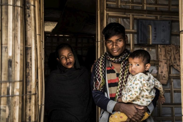 A Rohingya refugee family stand at the door of their shelter at Kutupalong camp.