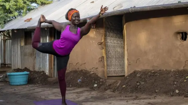 Rita Brown, réfugiée ougandaise et professeure de yoga, exécute un mouvement de yoga devant son logement dans le camp de Kakuma, au Kenya.