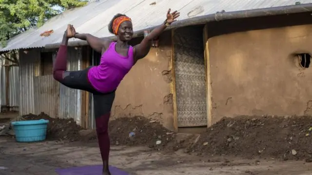 Rita Brown, a Ugandan refugee and yoga instructor, strikes a yoga pose.