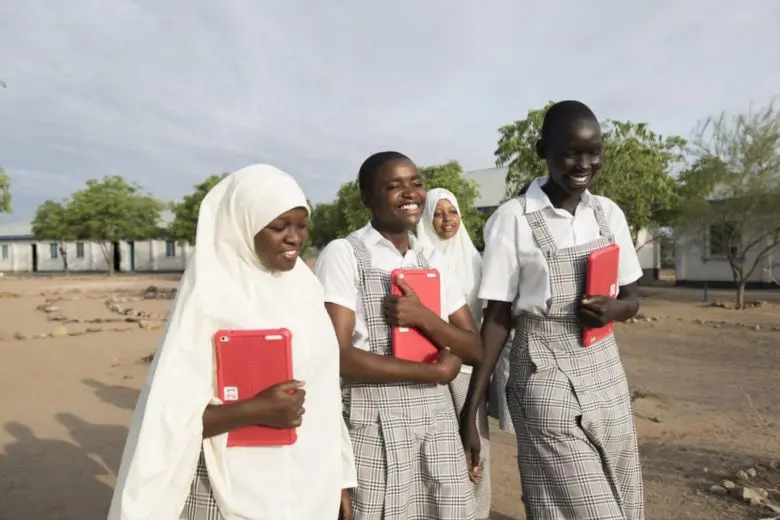 Young girls holding textbooks.