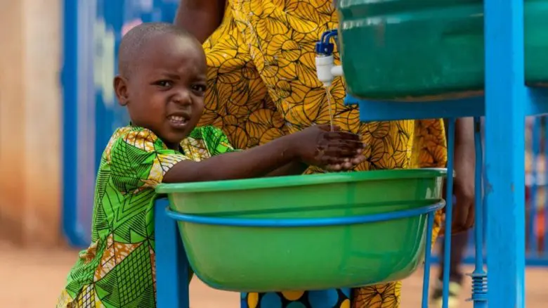 A young Burundian boy washes his hands