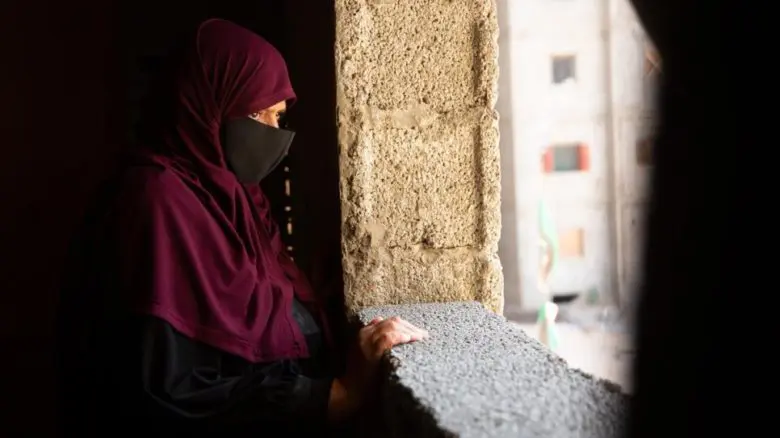 Libyan widow Hanan stands in the unfinished building.