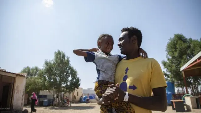 Berhane, 31 ans, un réfugié éthiopien avec sa fille au centre de réception frontalier de Hamdayet, à l'est du Soudan.