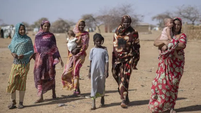 Malian refugees walk across arid terrain at Goudoubo camp, Burkina Faso, February 2020.