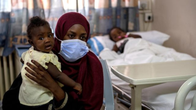 Une femme tient un enfant.