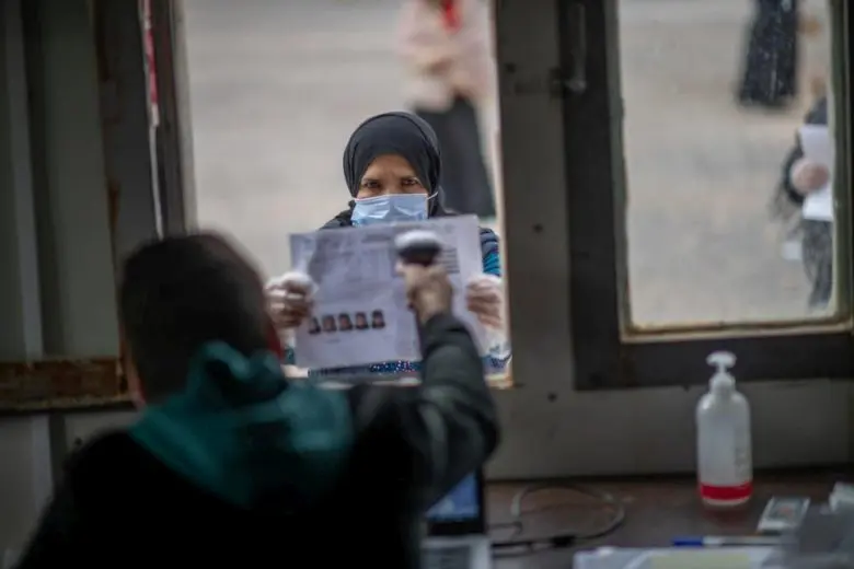 A Syrian refugee queues up to collect her winter cash assistance.