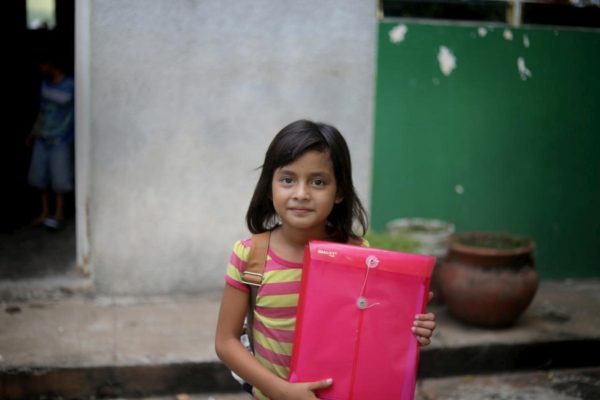 Une fillette originaire du Honduras tient le dossier des demandes d’asile de sa famille.