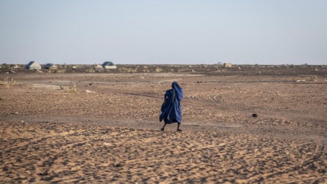Un homme traverse un terrain aride près de Kaya, au Burkina Faso.