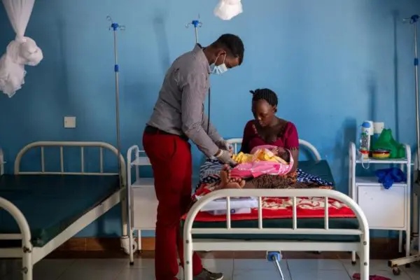 A health worker attends to a 23-year-old Burundian refugee after she delivered her baby girl at Natukobenyo health clinic in Kalobeyei settlement, Kenya.