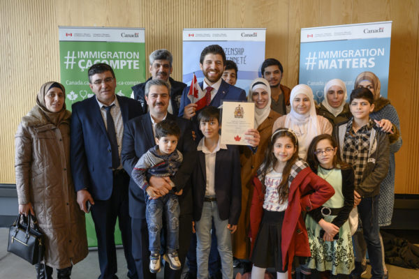 Tareq Hadhad, au centre, un réfugié syrien et le fondateur de Peace by Chocolate, prend la pose avec sa famille avant sa cérémonie de citoyenneté canadienne au Quai 21 à Halifax.