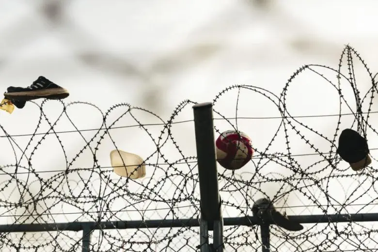 Des chaussures, un ballon et une casquette pris dans une clôture en fil de fer barbelé au centre de réception et d’identification de Fylakio, près de la frontière entre la Grèce et la Turquie. 