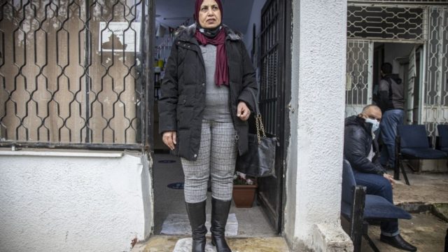 Woman standing in front of a health center in Jordan.