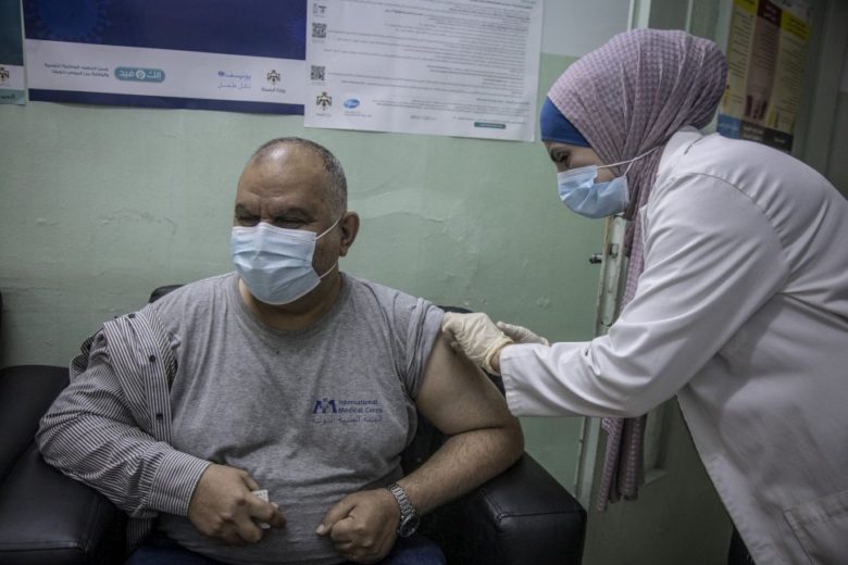 A man receives a vaccine from a medical worker.