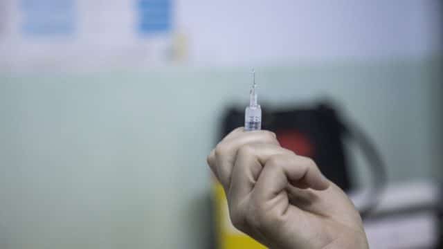 Un travailleur médical prépare le vaccin contre la Covid-19 qui sera administré à la réfugiée irakienne Raia Al Kabashi